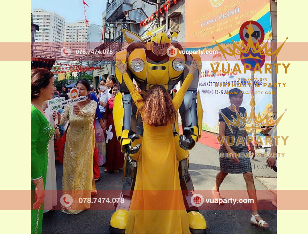 Robot bumblebee màu vàng do Vua Party cho thuê tại sự kiện check in cùng với khách mời sự kiện